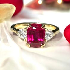 Indulge in the allure of this handcrafted, ring, featuring a gorgeous Lab Grown Red Ruby. This gem measures 9mm x 7mm and weighs 2.3 carats. On either side are sparkling top quality Moissanite. Not only does Moissanite test as a diamond it has double the brilliance and it's 100% ethical as is the ruby. All these gems were grown in a lab in Switzerland. Size is 6 1/4 - you can safely size this ring from 4 1/4 to 8 1/4 Please note that Many shops on Etsy are calling lab grown gems " natural ". The 40th Anniversary Gifts, July Birthstone Ring, Sparkle Top, Ethical Jewelry, July Birthstone, Lovely Ring, Halo Diamond Engagement Ring, Red Ruby, 3 Carat