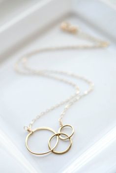 This gold circle necklace is a great addition to any minimalist's style outfit. These three interlocking 14k gold-fill rings are a constant reminder that we are all connected in one form or another. Attached to a delicate gold fill chain with a spring-ring clasp, it's pure simplicity and perfect for any occasion!..........PRODUCT DETAILS• Chain and findings are 14k gold-fill• Circles measure 37mm (1 7/16") by 18mm (11/16") (in diameter they are 18mm (11/16"), 15mm (9/16") and 12mm (1/2"))• Comes Jewelry For Moms, Wedding Jewelry Photography, Personalized Gold Jewelry, Minimalist Necklace Silver, Interlocking Rings, Interlocking Circle Necklace, Circles Necklace, Interlocking Ring, Circle Jewelry