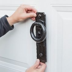 a person is opening a door with a black handle