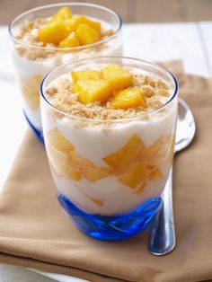 two glasses filled with dessert sitting on top of a table