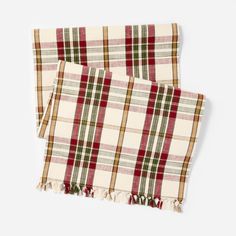 two red and green plaid scarfs with tassels on each side, one is folded