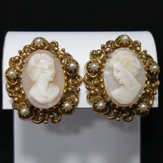 "*Description: This is a beautiful pair of Florenza carved shell earrings in a gold plated filigree frame with small faux pearl accents. The earrings are clip and are signed on the back side of each earring, FLORENZA, with the copyright symbol. These earring \"Ladies\" are each unique and it is obvious they are carved due to the unique features in their faces and the depth of each carving. Each unique cameo is set in gold plated filigree with five faux pearls on each earring. This would be a gre Victorian Cameo Earrings For Formal Occasions, Formal Carved Earrings, Vintage Baroque Earrings For Pierced Ears, Vintage Earrings With Intricate Design, Antique Clip-on Pearl Earrings For Wedding, Ornate Clip-on Earrings For Formal Occasions, Antique Clip-on Earrings For Anniversary, Vintage Antique Gold Earrings With Intricate Design, Antique Clip-on Jewelry For Vintage Events