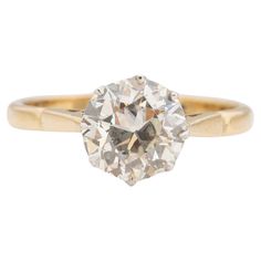 an old mine cut diamond engagement ring in yellow gold, set on a white background