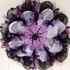 a purple and black spider web wreath on a door