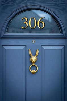 a blue front door with a gold metal knocker and number 3006 on it