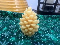 a pine cone candle sitting on top of a table