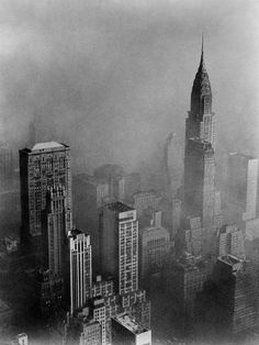 black and white photograph of skyscrapers in new york city, with the empire building visible