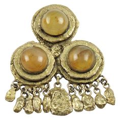 This lovely French Jewelry designer Henry Perichon (aka Henry) gilt bronze pin brooch has an undeniable medieval revival feel. The bronze metal frame boasts antique Middle-Age design influences and is ornate with polished pale yellow gemstone cabochons and complimented with dangling charms. The piece is engraved Henry at the back and has a security closing clasp and hook to use this brooch as a necklace or pendant. Measurements: 2.07 in wide (5.2 cm) x 2.63 in high (6.7 cm). Note: Henry Perichon French Jewelry Style, Medieval Revival, Victorian Pendant Necklace, Claudette Colbert, Bronze Bracelets, Victorian Pendants, French Jewelry, Yellow Gemstones, Antique Pendant