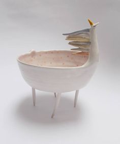 a ceramic bird sitting on top of a white bowl