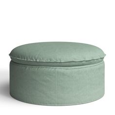 a small round ottoman with a light green cover on the top and bottom, sitting in front of a white background