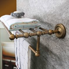 an old fashioned towel rack with two towels hanging on it's sides and a rolled up towel