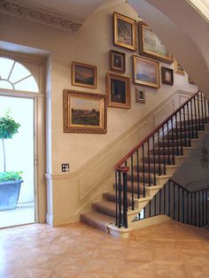 an entry way with stairs and pictures on the wall