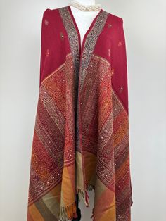 This is an all season wool shawl that measures 38""W X 85"L An XL blanket scarf or sofa throw in maroon, red, orange, and green with bead embellishments is a festive and versatile accessory.  Elevate your cozy evenings with our XL blanket scarf, a stylish and warm addition to your home. This maroon, red, orange, and green throw is adorned with delicate bead embellishments, adding a touch of festive charm to your space. ✨ Festive Elegance: The rich and vibrant colors of maroon, red, orange, and green make this blanket scarf the perfect companion for the holiday season. The added bead embellishments lend a touch of elegance and sparkle, making it an ideal festive wrap. 🛋️ Versatile Home Decor: Use it as a sofa throw to instantly transform your living room into a cozy and inviting space. Dra Red Pashmina Shawl With Motifs, Red Pashmina Shawl With Motifs And Traditional Drape, Red Pashmina Shawl With Motifs In Traditional Drape, Bohemian Red Pashmina Shawl With Motifs, Red Bohemian Shawl With Motifs, Embroidered Red Pashmina Shawl, Embroidered Red Pashmina Shawl For Festivals, Festive Shawl With Traditional Patterns, Red Pashmina Shawl For Festivals