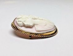 Large 10k Yellow Gold Oval Pink Conch Shell High Relief Cameo Brooch Pin PendantMetal: 10K yellow gold (acid tested)Weight: 33.6 gramsSize: 55mm long x 45mm wide (including frame), Sits 11mm off surface (at highest point)Hallmarked: Symbol of a roseHidden swivel fold down bail enables the brooch to be worn as a pendant or a pin Pin and closure work perfectlyThis is an estate piece in very good condition, it is in it's original worn state and can be re-polished upon request.Please see pictures fo White Oval Cameo Brooches, Yellow Gold Oval Cameo Brooch, Oval Cameo Brooch For Anniversary, White Oval Brooch For Anniversary, Classic Oval Brooches For Collectors, Oval Intaglio Brooches As A Gift, Oval Intaglio Brooches For Gifts, Oval Intaglio Brooches For Anniversary, Heirloom Oval Brooches For Gifts