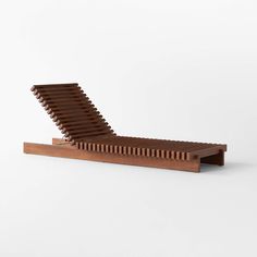 a wooden chaise lounger sitting on top of a white floor