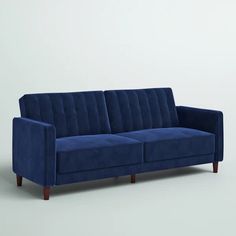 a blue couch sitting on top of a white floor