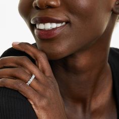 a close up of a person with a ring on her finger and wearing a black shirt