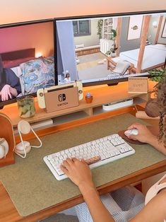 a woman sitting at a desk with a keyboard and mouse in front of two monitors