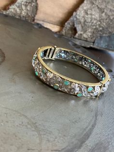 "This is unique Victorian style hinged bangle bracelet with natural emerald and rose cut diamonds. They diamonds are Polki which is described as an uncut diamond with one flat side and the other cut to a taper or point. The bracelet's design has clovers set with diamonds and other diamonds and emeralds set evenly in between. There are two (2) diamonds missing from the petals of two (2) clovers(pictured). The outside of edge of the bangle has a textured design. The bracelet has a push deployment Gemstone Bangle, Sterling Silver Bangle, Rose Quartz Beads, Textured Design, Uncut Diamond, Diamond Bangle, Sterling Silver Bangles, Silver Bangle, Hinged Bangle