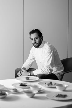 a man sitting at a table with plates on it