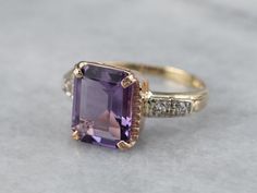 "This stunning amethyst ring has a pretty medium purple amethyst in the center, that really flashes and flickers with vibrant violet and raspberry reflections! Set into a unique multi-color gold mounting with sparkling diamond shoulders, this sweet ring would be a beautiful addition to anyone's collection! Metal: 14K Yellow, Rose, and White Gold Gem: Amethyst 3.05 Carats Gem Measurements: 11.0 x 8.7 mm, Emerald Cut Accents: 4 Diamonds totaling .08 Carats, F in Color, VS in Clarity Ring Size: 7.5 Gold Amethyst Ring, Right Hand Ring, Sweet Ring, Amethyst And Diamond Ring, Ring Birthstone, Right Hand Rings, Amethyst Gem, Hand Ring, Sparkling Diamond