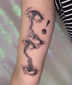 a woman's arm with a black and white tattoo design on the left forearm