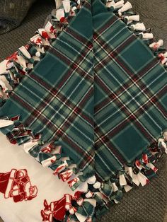 two green and white plaid scarves laying on top of each other next to a pair of shoes