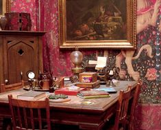 a table with many books on it in front of a painting