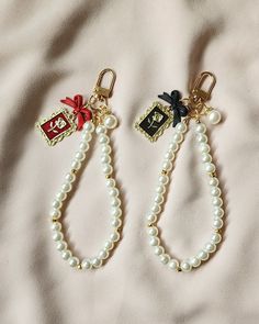 Vintage pearl keychain with flower charms. These are highly durable and perfect to accessorize your purse, airpods or keys.  Circumference measures 8.5 inches. **Please ensure that you are not stretching the keychains as they will  break. These do NOT stretch. If you would like a certain sizing please contact us. No refunds or replacements.** Vintage Keychain Aesthetic, Pearl Key Chain, Elegant Bag Charm With Lobster Clasp For Gift, Elegant Bag Charm With Lobster Clasp As Gift, Elegant Bag Charm With Charms As Gift, Elegant Keychain With Key Leash As Gift, Black Rectangular Keychain For Gift, Black Rectangular Keychain Perfect For Gifts, Keychain Charms Diy