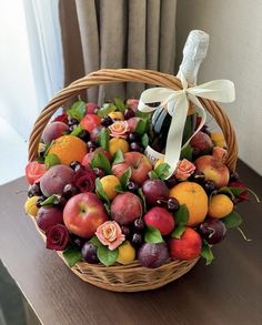 a basket filled with lots of fruit on top of a table next to a window