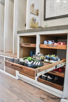 two wooden shelves with shoes in them on top of a hard wood floor next to a white wall