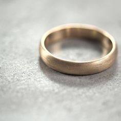 a gold wedding ring sitting on top of a table