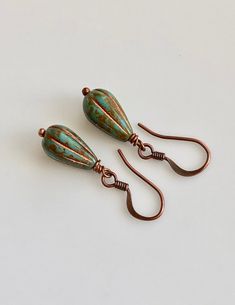 "boho earrings small dangle earrings turquoise glass earrings These beads are small teardrop, melon shaped Czech glass. They are turquoise with a metallic copper coating, which highlights the grooves in the beads. They dangle from small, antiqued copper plated brass hook ear wires. Length of earrings from top of ear wires is only 1 1/4\". Glass bead measures 13mm, 1/2\". You can enter my shop here: gypsydangles.etsy.com" Small Dangle Earrings, Brass Hook, Small Boho, Metallic Copper, Earrings Turquoise, Turquoise Glass, Leverback Earrings, Turquoise Green, Triangle Earrings