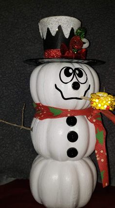 a snowman with a hat and scarf on it's head is holding candy