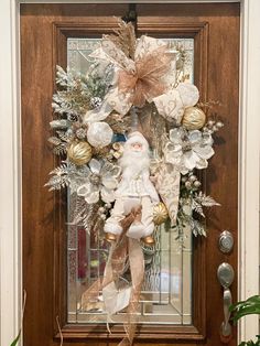 a christmas wreath on the front door with santa clause and ornaments hanging from it's side