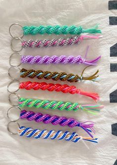 six different colored braided key chains on top of a white sheet