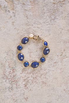 Add a touch of sophistication to your outfit with our Lapis Lazuli Stone Bracelet. Featuring shimmering, round and oval-shaped lapis lazuli gemstones with a gold finish, this bracelet will instantly elevate your style. Elegant Sapphire Faceted Bracelets, Gold Lapis Lazuli Bracelet With Gemstone, Gold Lapis Lazuli Gemstone Bracelet, Elegant Bracelets With Natural Stones, Elegant Blue Lapis Lazuli Bracelet, Elegant Natural Stones Oval Bracelet, Elegant Blue Faceted Bracelets, Elegant Lapis Lazuli Gemstone Bracelets, Lapis Lazuli Stone