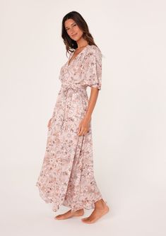 A flowy short flutter sleeve maxi dress in a pink floral print. Floral print Relaxed fit Short flutter sleeves Maxi length Asymmetric hemline V-neckline Elastic waist Self-tie waist belt Lined Bohemian maxi dress Feminine florals add a pretty touch to this classic boho maxi dress. With short flutter sleeves, a flattering v-neckline, and a waist-defining tie belt. The unique asymmetric hemline adds a sweeping touch to the long flowy skirt. Model is 5'9, wearing a size S.Style: I-73347WL-SKF-CG Flowy Summer Wrap Dress With Flutter Sleeves, Feminine Flowy Maxi Wrap Dress, Feminine Flowy Maxi Dress With Surplice Neckline, Feminine Flowy Maxi Length Wrap Dress, Flowy Feminine Maxi Length Wrap Dress, Pink Belted V-neck Midi Dress, Feminine V-neck Maxi Dress With Tie Waist, Beach Maxi Dress With Tie Waist And Short Sleeves, Spring Flowy Wrap Dress With Flutter Sleeves