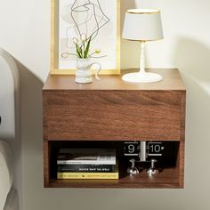 a nightstand with books and a lamp on it