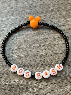 It's really not so scary!  Trick or Treating at a Boo Bash party?  Well this is the perfect accessory for you!  Handmade beaded elastic bracelet with black glass seed beads, round letter discs and an orange mouse ears bead to complete this piece!  Wear it to the parks or all spooky season long!  Bracelets are available in a variety of lengths.  Pick your custom length from the drop down menu below.  All our bracelets are made with quality in mind.  With that being said, all bracelets should be t Novelty Beaded Bracelets For Halloween, Black Beaded Bracelets For Party In Novelty Style, Adjustable Beaded Stretch Bracelet For Halloween, Black Novelty Stretch Bracelet, Disney Beads, Boo Bash, Not So Scary Halloween, Halloween Bracelet, Friendship Bracelets Designs