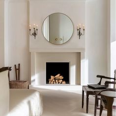 a living room with a fire place and mirror on the wall next to a bed