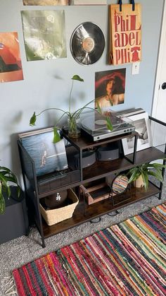 a living room with a rug and various pictures on the wall above it, along with an entertainment center