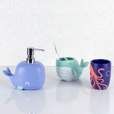 three bathroom accessories including soap dispenser, toothbrush holder and cup on counter