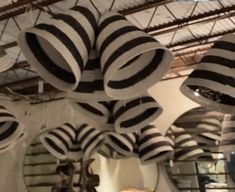 many black and white hats hanging from the ceiling in a room filled with other items