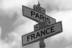 two street signs on top of each other in front of a cloudy sky with clouds