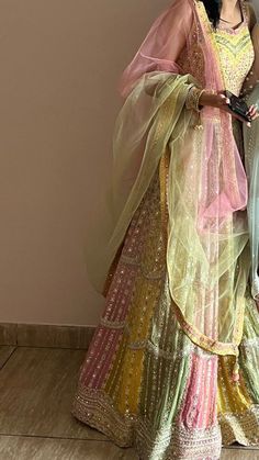 a woman in a colorful dress standing next to a wall