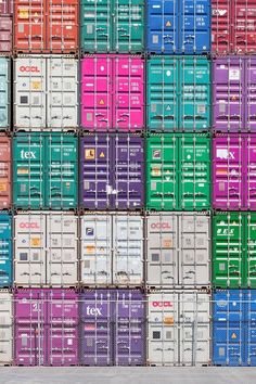 a large stack of colorful shipping containers stacked on top of each other in different colors