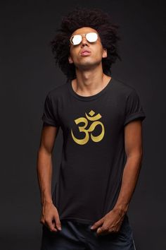 This stylish unisex, black 'Golden OM' t-shirt with gold lettering fits like a well-loved favorite. Super soft cotton and excellent quality print make one fall in love with it over and over again.This shirt feels soft and lightweight, with the right amount of stretch. It's comfortable and flattering for both men and women.It is a perfect gift for anyone who loves spirituality, yoga, and meditation. 100% soft spun cotton 4.4-ounce and 30 singles 1x1 rib knit neck Double-needle sleeves and hem Sho Gold T-shirt With Letter Print For Summer, Black Screen Print Tops For Festival, Gold Letter Print Tops For Summer, Gold Letter Print Top For Summer, Casual Letter Print Tops For Festivals, Casual Relaxed Fit T-shirt For Festivals, Casual Gold T-shirt With Logo Print, Gold Tops With Logo Print For Streetwear, Trendy Festival T-shirt With Crew Neck