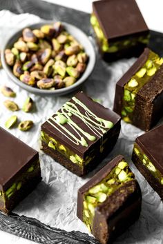 several pieces of chocolate cake with pistachios on top