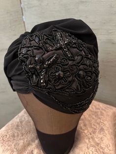 Vintage 1990 unusual turban design, the  black, spandex jersey base has one snap in the back that closes the hat. The front is gathered and has a beautiful sequined and beaded piece on the side/front. The crown can be worn open or closed. Very comfortable and glamorous.  One size Beaded Fitted Headpieces For Party, One Size Black Turban For Party, Black Fitted Turban For Party, Evening Fitted Turban, Adjustable Black Headwrap For Party, Party Headwrap One Size Fits Most, Black Party Turban Headband, One Size Black Headwrap For Party, Black Headband Turban For Party